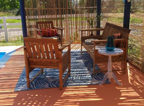 two chairs and a table on a patio at Cabañas El Desván in Puente Negro