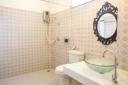 a bathroom with a sink and a toilet and a mirror at The Harmony Resort in Suan Phung