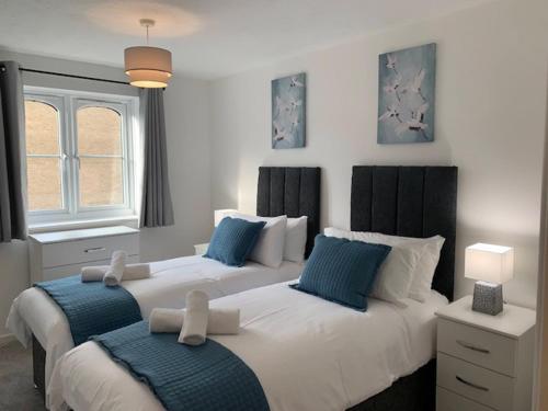 Duas camas num quarto com azul e branco em Watford Gemini - Eton 1 - Nr Watford Junction, M1 ,M25 em Watford