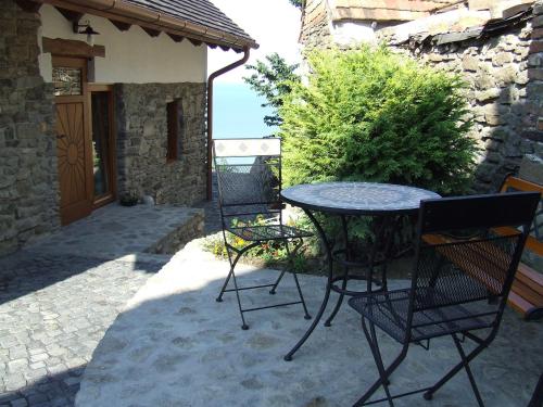 a patio with a table and chairs and a building at Csátó Vendégház in Tihany