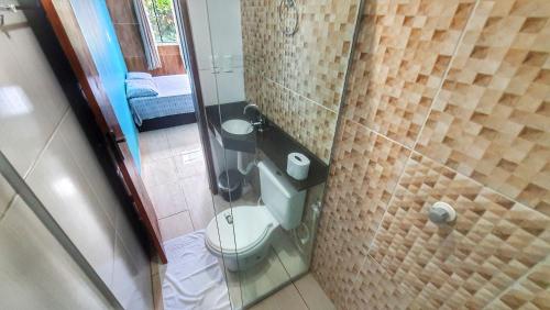 a small bathroom with a toilet and a shower at Cantinho da Sarah in Maragogi