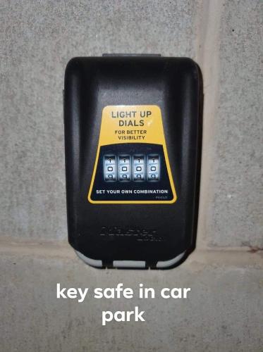a key safe in car park sign on a wall at Heart of Airlie Beach Apartment in Airlie Beach