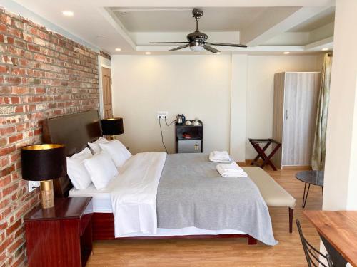 a bedroom with a bed and a brick wall at Shalom Farmhouse by the hillside in Imphal