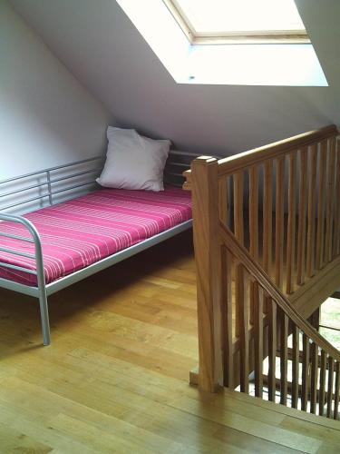 a futon bed in a attic with a skylight at La Bergerie du festel in Saint-Riquier
