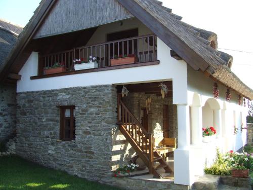 a house with a staircase and a balcony at Csátó Vendégház in Tihany