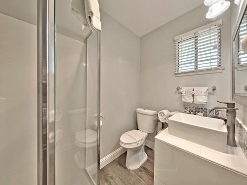 a white bathroom with a toilet and a sink at Heavenly Inn Lake Tahoe in South Lake Tahoe