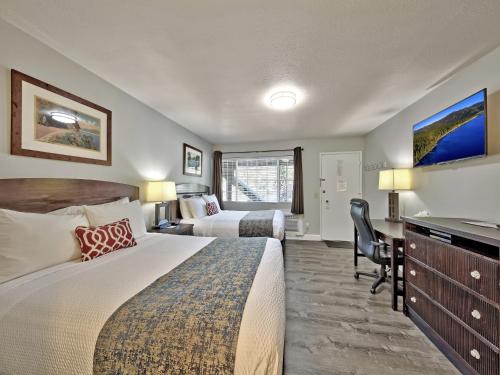 a hotel room with two beds and a desk at Heavenly Inn Lake Tahoe in South Lake Tahoe