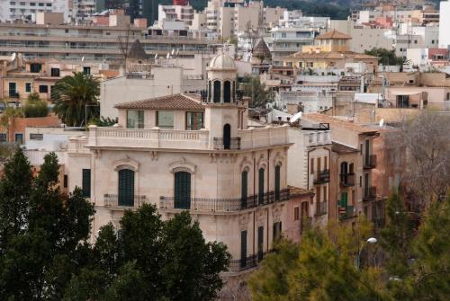 an old building with a clock tower in a city at Hotel Hostal Cuba in Palma de Mallorca