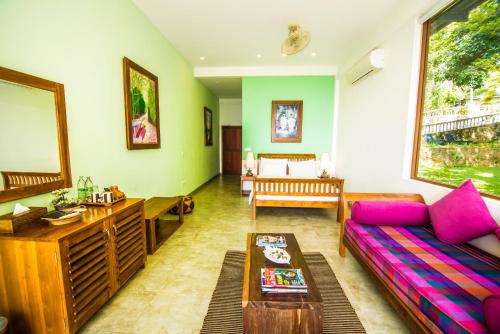 a living room with a couch and a table at Ella Planters Bungalow in Ella