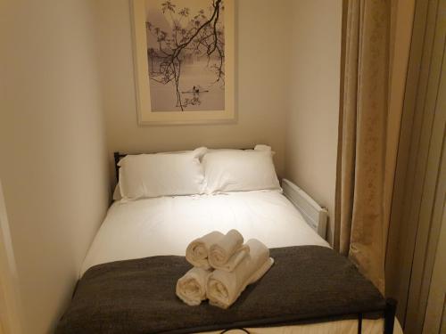a room with a bed with towels on it at Birmingham Amethyst, 3 bedroom Apartment in Birmingham