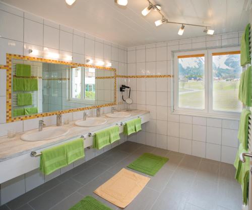 a bathroom with three sinks and two mirrors at Apartment Österreich in Ramsau am Dachstein