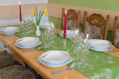 a wooden table with plates and glasses on it at Apartment Österreich in Ramsau am Dachstein