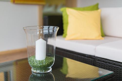 a candle in a glass vase on a table at Apartment Österreich in Ramsau am Dachstein