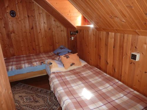 una camera con due letti in una cabina di legno di Roubenka u vleku a Josefŭv Dŭl