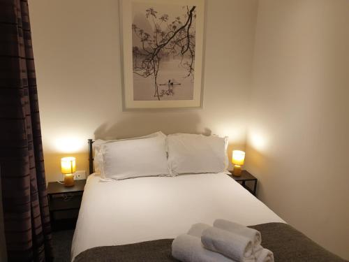 een slaapkamer met een bed met twee handdoeken erop bij Birmingham Garnet, 3 bedroom Apartment in Birmingham