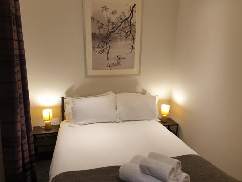 a bedroom with a bed with two towels on it at Birmingham Garnet, 3 bedroom Apartment in Birmingham