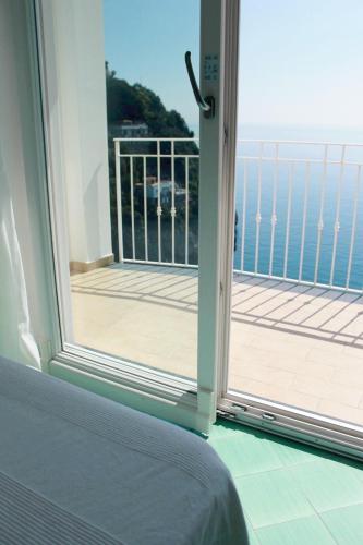 a door to a balcony with a view of the ocean at Residence Due Torri in Maiori