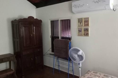 a room with a fan and a chair and a window at NIDHIVANA FARMS & RESORT, bakrebail-salethoor rd, Mangalore in Mangalore
