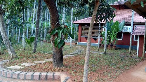 a house in the middle of a forest of trees at NIDHIVANA FARMS & RESORT, bakrebail-salethoor rd, Mangalore in Mangalore
