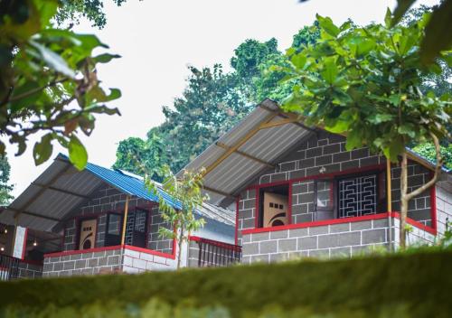 a small house with a blue roof at STAYMAKER River Wood Residency in Dandeli