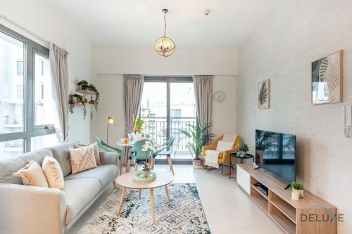 a living room with a couch and a tv at Blissful 1BR in Safi Town Square by Deluxe Holiday Homes in Dubai