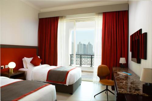 a hotel room with two beds and a window at Retaj Baywalk Residence in Doha