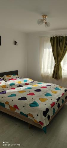 ein Bett mit farbenfroher Decke in einem Schlafzimmer in der Unterkunft Casa M in Câmpulung Moldovenesc