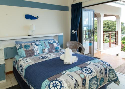 a bedroom with a bed with a blue and white comforter at Sea View townhouse in Zinkwazi Beach in Zinkwazi Beach