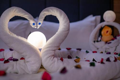 two towels shaped like swans sitting on a bed at لافنت بارك للشقق المخدومة - إقتصادي in Jeddah