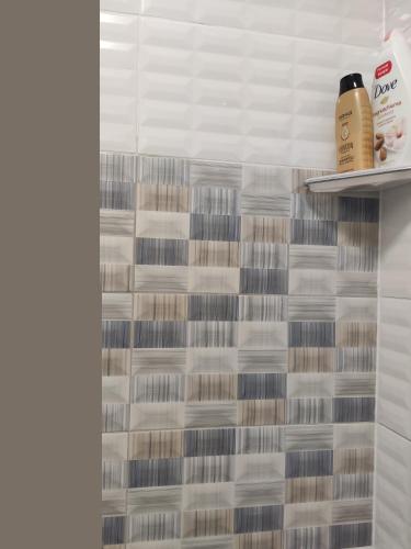 a shower with white and brown tiles in a bathroom at Villa Ivanovi in Ohrid