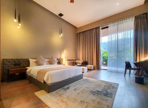 sypialnia z dużym łóżkiem i dużym oknem w obiekcie Aria Resort & Spa - Pure Veg w mieście Nashik