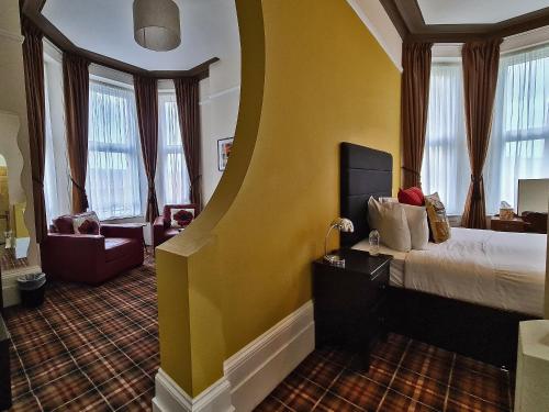 a hotel room with a bed with a yellow wall at 10to12 Folkestone in Folkestone