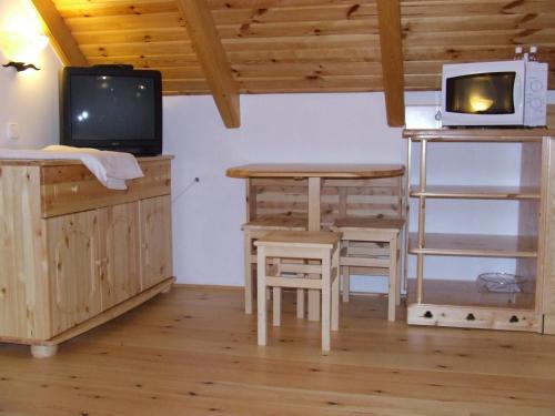 a room with a desk and a tv and a table at Csátó Vendégház in Tihany
