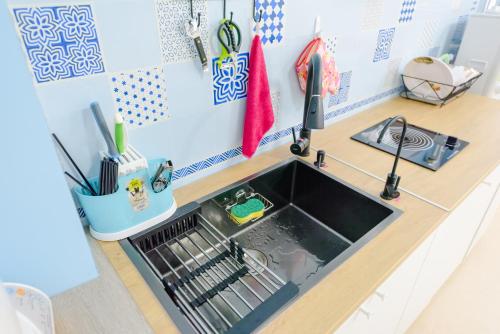 un fregadero de cocina con un estante para platos en Gold Coast B&B, en Huxi