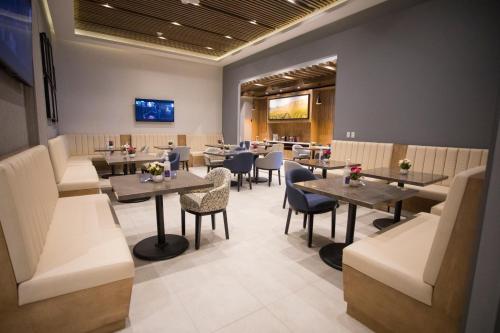 a restaurant with tables and chairs in a room at Hyatt Place Saltillo in Saltillo