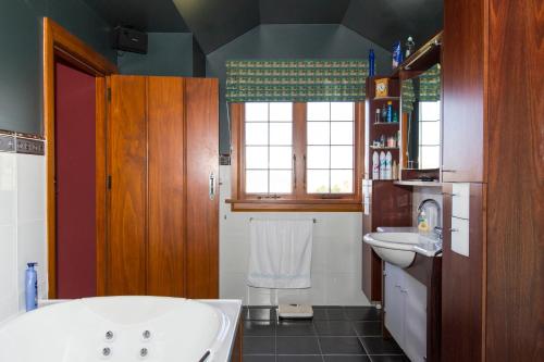 a bathroom with a tub and a sink at Woodroyd Estate holiday sanctuary in Island Bay