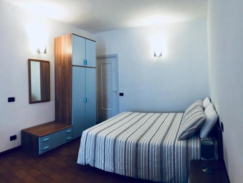 a bedroom with a bed with a dresser and a mirror at Sara Apartment, Comfort and lateral sea view in Riomaggiore
