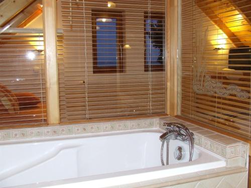 uma banheira na casa de banho com uma janela em Csátó Vendégház em Tihany