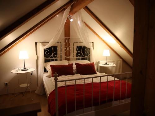 a bedroom with a red bed with two lamps at Haus Janina in Rieste
