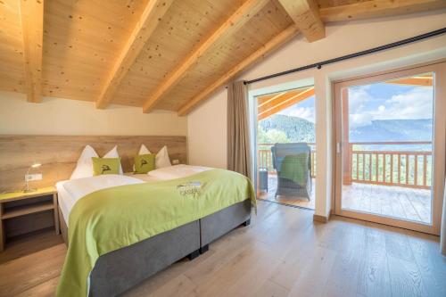 a bedroom with a bed and a large window at Gasserhof Chalets in Meltina
