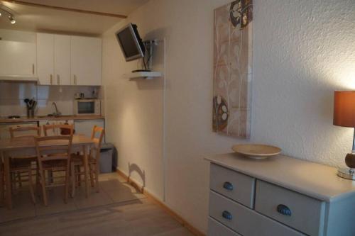 a kitchen and dining room with a table and chairs at T2 Immeuble Chanteclerc 6 personnes 37m2 PRALOUP 1600 in Uvernet-Fours