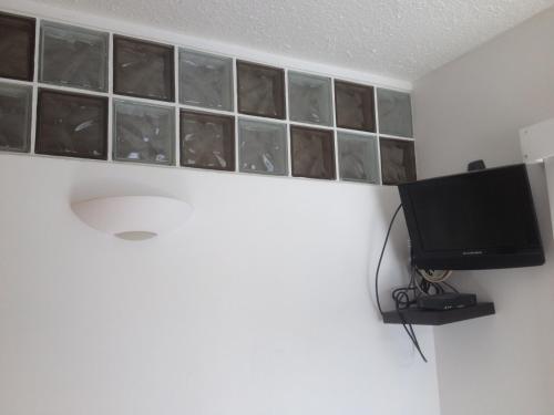 a room with a tv and a wall with glass squares at T2 Immeuble Chanteclerc 6 personnes 37m2 PRALOUP 1600 in Uvernet-Fours