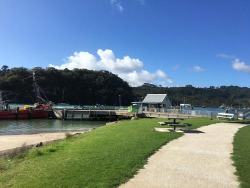 a picnic table on the grass next to a dock at Whitianga Motel in Whitianga