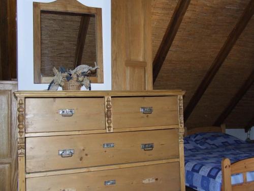 a wooden dresser in a bedroom with a bed at Csátó Vendégház in Tihany
