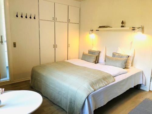a bedroom with a large bed with white cabinets at Sandkaas Badehotel in Allinge