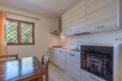 a kitchen with a table and a stove top oven at Sardinia Family Villas - Villa Brunilde with private pool in Arzachena