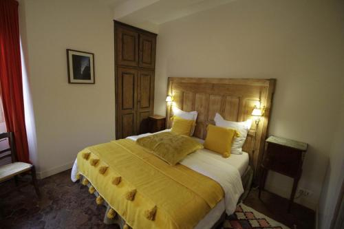 um quarto com uma cama grande com lençóis e almofadas amarelos em Coté-Serein La Privilège de la Tour Madame em Noyers-sur-Serein