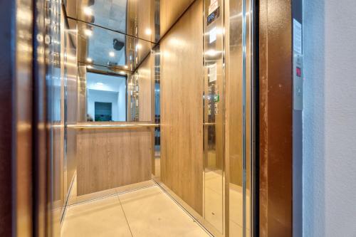 - un couloir avec des portes en bois et un miroir dans l'établissement Apartman Aroma Lux 25, à Zlatibor