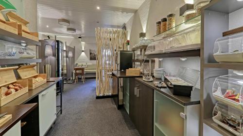 a large kitchen with counters and shelves with food at Suit' & Frühstück Zum Latschen - Adults Only in Mauth