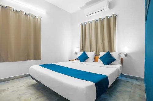 a bedroom with a large bed with blue pillows at ELITE ROOMS in Hyderabad